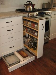 an open cabinet in the middle of a kitchen