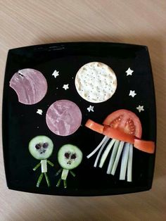 a black plate topped with food on top of a wooden table