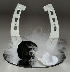 two hats with white feathers on a black plate