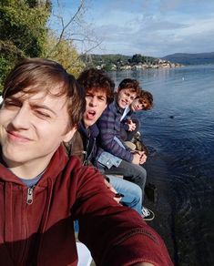 a group of young men sitting next to each other near the water