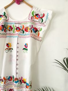 "This beautiful huipil is a traditional dress from Oaxaca, it is a loose dress, made of a very basic and comfortable design pattern. It can be worn with a skirt down and looks spectacular, with a bohemian touch, a relaxed style and at the same time looks very elegant for a party in the morning or afternoon. It is made of 100% cotton blanket fabric. Size Large Width 22\"-23\" Length 42'-43\" Size XL Width 24\"-25\" Length 42\"-43\"" Folk Style Embroidered Dress For Fiesta, Bohemian Style Embroidered Dress For Fiesta, Folk Style Floral Embroidered Dress For Cinco De Mayo, Traditional Cotton Embroidered Dress For Cinco De Mayo, Traditional Embroidered Cotton Dress For Cinco De Mayo, Bohemian Multicolor Embroidered Dress For Cinco De Mayo, Bohemian Embroidered Cotton Dress For Cinco De Mayo, Traditional Mexican Dress, Embroidered Robes