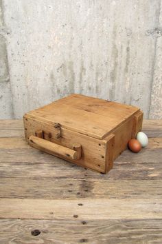 an old wooden box sitting on top of a wooden table next to two eggs in it