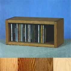 a wooden entertainment center with dvd's in it on top of a blue background