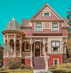 an old victorian style house with purple trim on the front porch and stairs leading up to the second floor