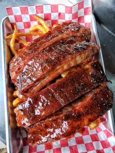 ribs and french fries in a tray on a table