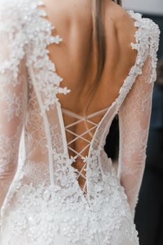 the back of a woman's wedding dress with lace detailing and openwork on it