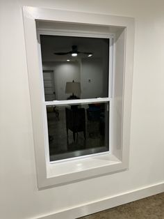 an empty room with a ceiling fan in the window