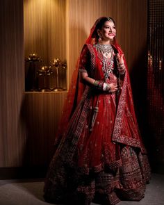 a woman in a red bridal gown posing for the camera