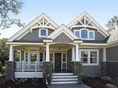 a gray house with white trim and two story front porches on the first floor