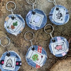 six embroidered keychains are sitting on the ground next to some grass and dirt