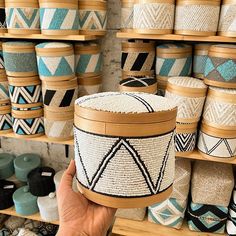 a person holding up a basket in front of shelves with baskets on it and other items