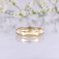 two gold wedding bands with flowers in the background