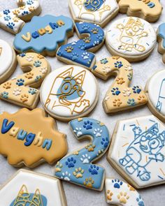 decorated cookies with blue, yellow and white frosting on a table top next to each other