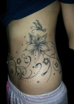 a woman's stomach with a flower tattoo on it and stars around the bottom