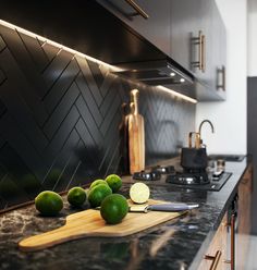 some limes are sitting on a cutting board in the middle of a kitchen counter