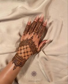 a woman's hand with henna on top of it and the bottom half of her arm