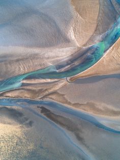 an aerial view of the water and sand