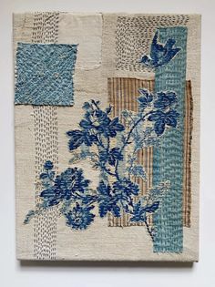 a piece of cloth with blue flowers and stripes on the fabric is hanging on a wall