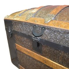 an old wooden trunk with metal handles and decorative carvings on the top, sitting against a white background