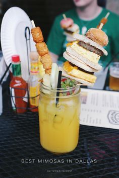 a person sitting at a table with food and drinks