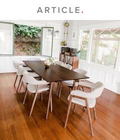 a dining room table with white chairs around it