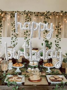 a table topped with lots of desserts and balloons that say happy birthday on it