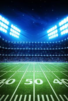 an american football stadium with the lights on and fifty yard line illuminated by floodlights