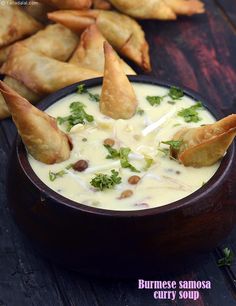 some food is in a bowl on a wooden table with other foods and garnishes