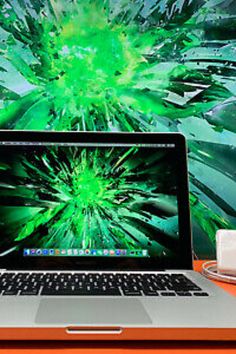 an open laptop computer sitting on top of a wooden desk next to a cup of coffee