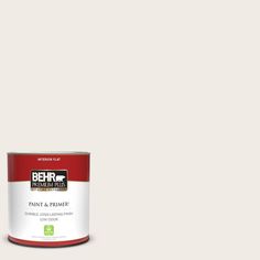 a can of red paint sitting on top of a white floor next to a wall