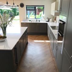 a large kitchen with stainless steel appliances and wood flooring is pictured in this image