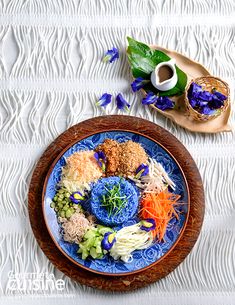 a blue and white plate topped with different types of food on top of a table