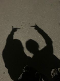 the shadow of a skateboarder holding his hand up