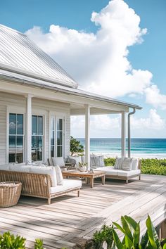 a porch with wicker furniture on it and the ocean in the background at this beach house