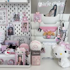 a white teddy bear sitting next to a shelf filled with stuff animals and other items