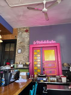 the inside of a restaurant with pink and yellow doors