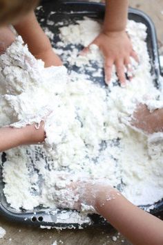 two children are playing with flour in a pan