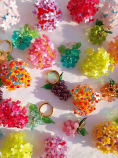 many different colored beads and rings on a white surface