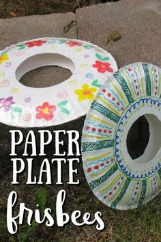 paper plate frisbees sitting on the ground in front of some grass and flowers