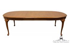 an oval wooden table with two leaves on the top and one leaf at the bottom