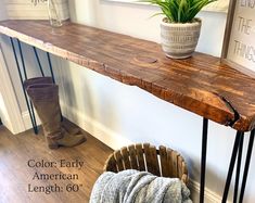 a wooden table sitting on top of a hard wood floor next to a potted plant