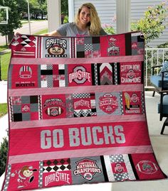 a woman is holding up a quilt that says go buck's on the front