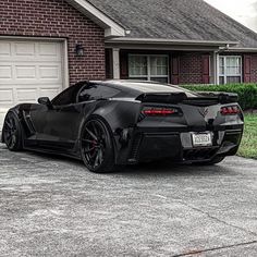 a black sports car parked in front of a house