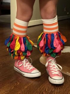 a child's feet wearing pink sneakers with colorful ruffles