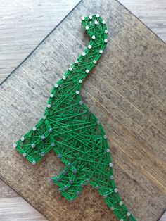 a green string art piece sitting on top of a wooden table