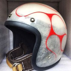 a helmet with red paint on it sitting in a box