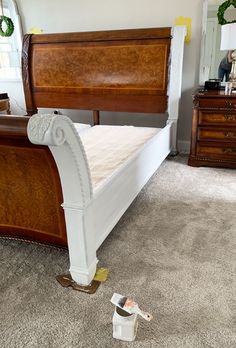 a white bed sitting on top of a carpeted floor next to a wooden dresser