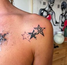 a man with a star tattoo on his back shoulder and chest is looking at the camera