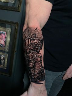 a man with a black and grey tattoo on his arm