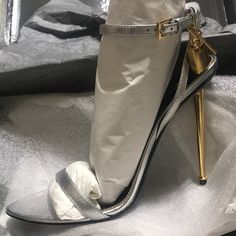 Tom Ford 105mm Sandal In Metallic Leather. Sz 40 Signature Hanging Padlock And Key Charm. 4.3" Metallic Stiletto Heel. Pointed Open Toe. Adjustable Halter Ankle Wrap. Leather Outsole. Made In Italy. New In Box With Extra Heel Taps, Dustbag Luxury Open Toe Heels With Metal Feet, Luxury Silver Sandals With Sculpted Heel, Luxury Heels With Metal Feet For Party, Luxury Party Heels With Metal Feet, Silver Sandals With Sculpted Heel For Formal Occasions, Silver Sandals With Sculpted Heel For Cocktail, Silver High Heels With Heel Strap, Chic Metallic Silver Heels With Heel Strap, Silver Heels With Sculpted High Heel